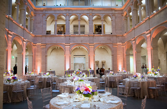 The Calderwood Courtyard set up for an evening event with round tables, white linens, white chairs, and elegant dinnerware.